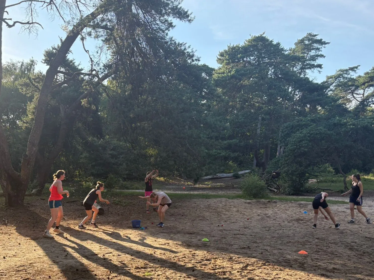 Groep vrouwen speelt een spel buiten in het bos tijdens een SheMoves training