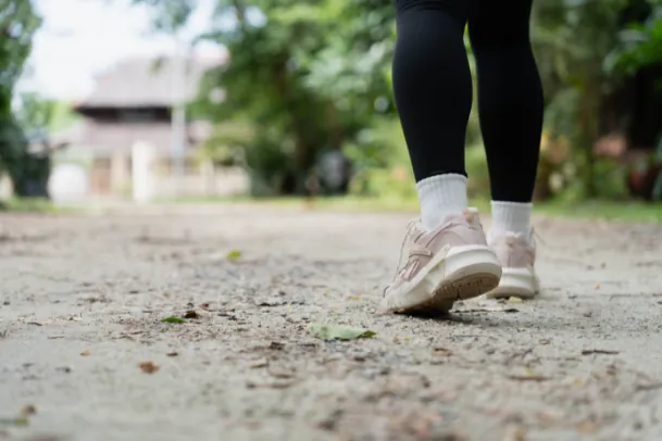 Vrouw loopt buiten op een bospad, gezien van achteren